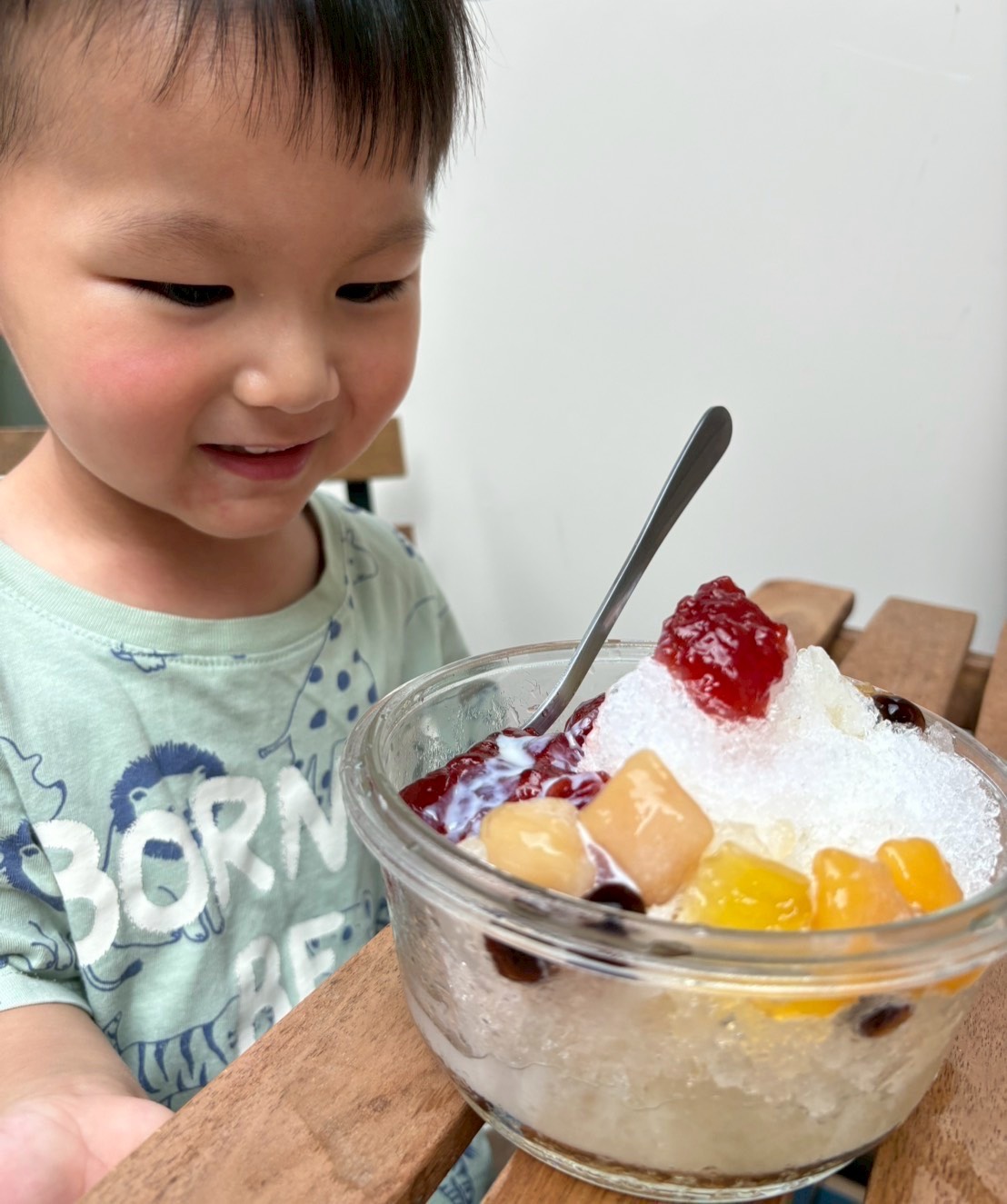 孩子看著一碗水果雪花冰露出期待表情